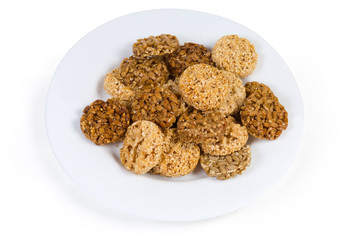 Round sesame and sunflower seed candies on the white dish