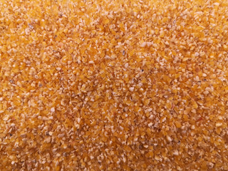 Small orange corn grits - abstract background, texture.