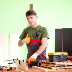 Young man carpenter working in workshop