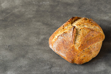 Whole grain bread Loaf or Boule isolated on the right side. Grey background. Copy space. Bakery concept. 