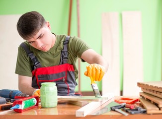 Young man carpenter working in workshop