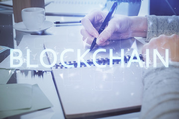 Cryptocurrency hologram over woman's hands writing background. Concept of blockchain. Multi exposure