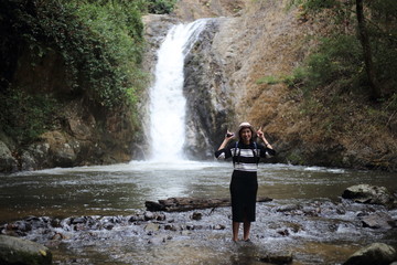 A woman standing in Chae son waterfall of Chae son nation park in Lampang at Thailand