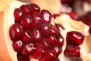 Pomegranate seeds macro shot. Peeled Pomegranate. A slice of ripe pomegranate closeup.