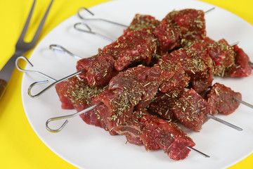 brochettes de boeuf cru dans une assiette