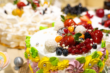 Cakes and pastries in a shop window. Pastry shop with variety of donuts, Creme brulee, cakes with fruits and berries