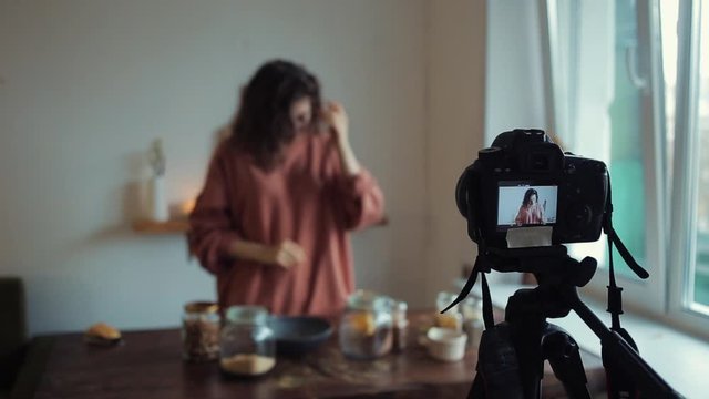 Blurred shot of a blogger girl in her kitchen who talks about food for her blog