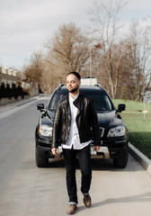 Portrait of fashionable well dressed man with beard posing outdoors