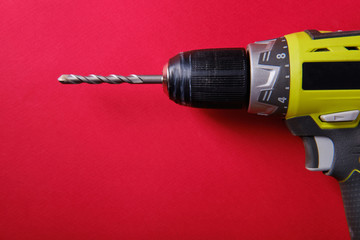 Screwdriver on a red background, top view, place for an inscription