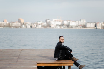 Portrait of fashionable well dressed man with beard posing outdoors