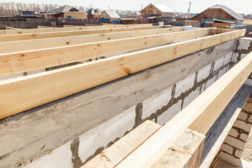 Under construction house walls made from white aerated autoclaved concrete blocks. Woods elements and components of the construction of roof. Ceiling beams of natural eco-friendly materials. top view