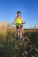 Fototapeta na wymiar Young sporty woman with a bike, soft focus background
