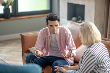 Young man in a pink shirt looking involved