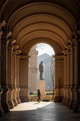 Columns of historical building in Budapest with statue at the end