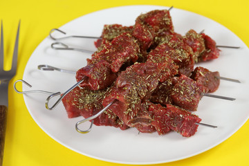 brochettes de boeuf cru dans une assiette