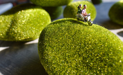 Group of traveler miniature people figures ride motorcycle, green concept