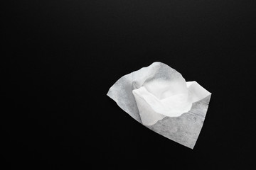 Prevention and protection against the spread of viruses and diseases. White antibacterial cleaning wipes for hands on a black background