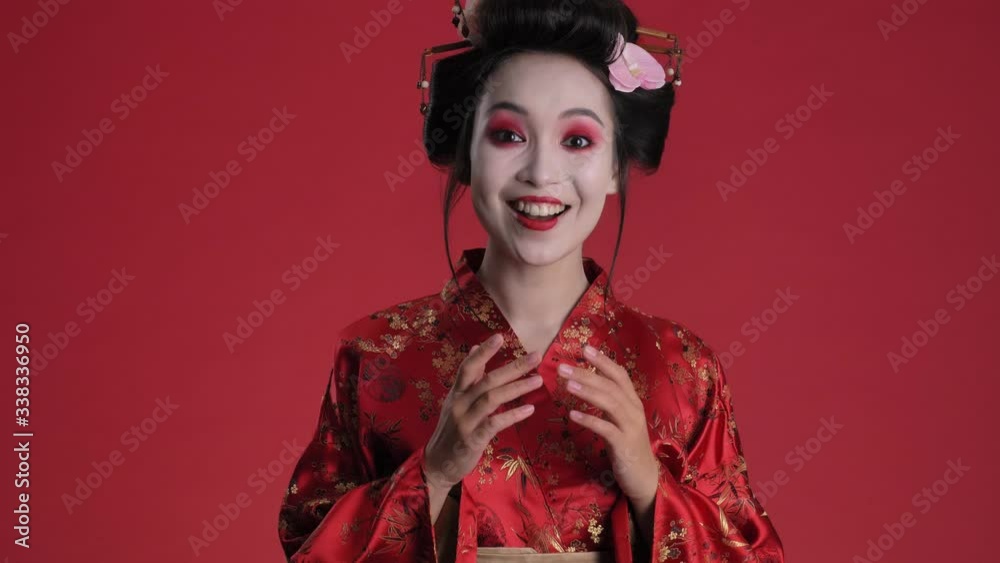 Poster a surprised young geisha woman in traditional japanese kimono is rejoicing standing isolated over re