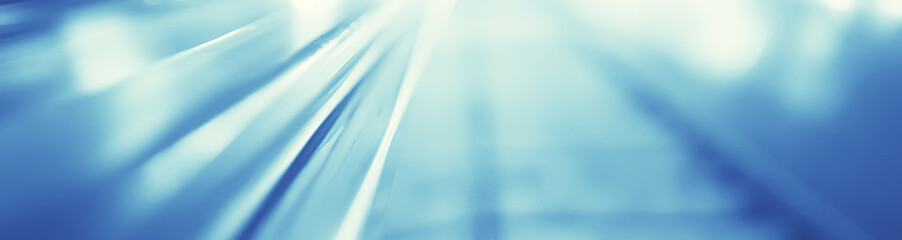 blurred background metro escalator / light blue background movement city infrastructure subway