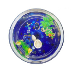Round aquarium with a fish and blue stones at the bottom. Aquarium on a white background. View from above
