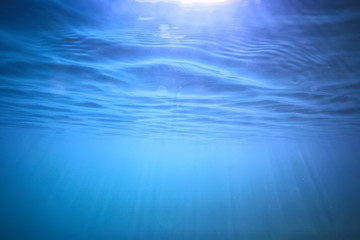 ocean water blue background underwater rays sun / abstract blue background nature water