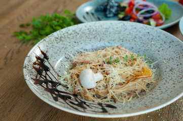 carbonara in a turquoise plate on the table
