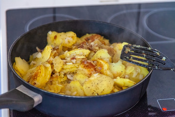 Bratkartoffeln in der Bratpfanne steht auf dem Herd in der Küche zum Mittagessen