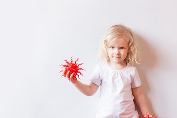 caucasian little girl playing with red virus model over white background..Virus, pandemic, quarantine and transmission concept . Concept of medicine and healthcare in the fight against viruses.
