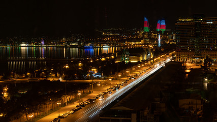 Fototapeta na wymiar Baku, Azerbaijan - July 2019: Baku cityscape at night with Caspian Sea and Flame Towers