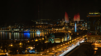 Fototapeta na wymiar Baku, Azerbaijan - July 2019: Baku cityscape at night with Caspian Sea and Flame Towers