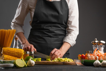 Cooking seafood salad. Chef slices zucchini. Cooking and recipe book. Hotel or restaurant business