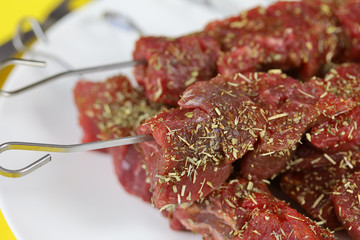 brochettes de boeuf cru dans une assiette