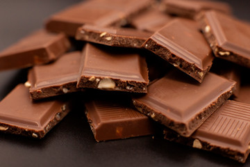 Chunks of chocolate with nuts on a dark background