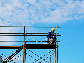 Fototapeta premium Man Working on the Working at height on construction site with blue sky