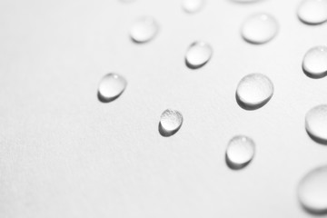 Water drops with selective focus on white background, macro. Concept moisturizing close-up. Aqua...