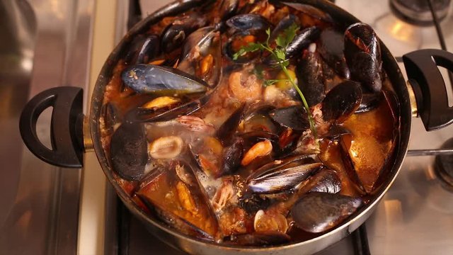 Cooked on the stove traditional Italian Mediterranean fish soup, chowder,with shrimp, mussels tomato, squid, clams.Seafood.Top view