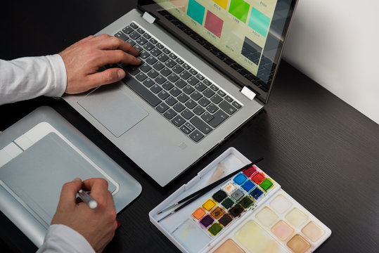 Top view of designer creating with the laptop and graphic tablet on a wood table. Concept desktop studio design.