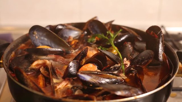 Cooked on the stove traditional Italian Mediterranean fish soup, chowder,with shrimp, mussels tomato, squid, clams.Seafood.