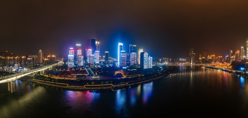 Panoramic aerial night view of Hong Ya Dong cave and skyscrapers by Jialing river in Chongqing, southwest China