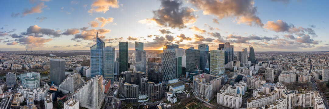 Aerial panoramic drone shot of La Defense skycraper in Paris business district with clouds during sunset