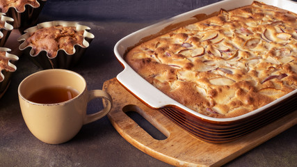 pie or muffin with apples on a plate in blue classic color with tea in the kitchen