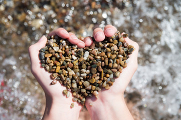 Heart shaped handful of pebbles