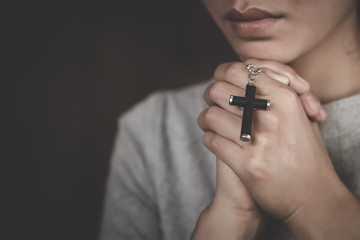 Hand of woman while praying for christian religion, Casual woman praying with a cross, Religion...