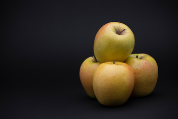four apples on a black background