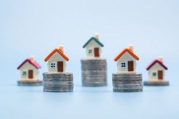 miniature houses among pile of coins, Housing industry mortgage plan and residential tax saving strategy, mortgage, investment, real estate and property concept