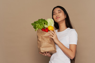 woman holding a shopping bag full of groceries