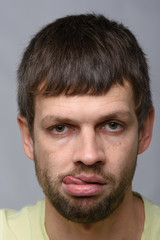Fototapeta premium Portrait of a sad man of European appearance with his tongue hanging out, close-up