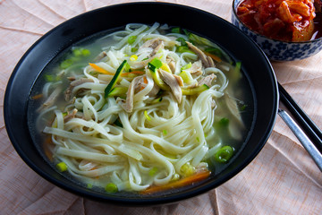 Korean chicken noolde soup which is called Dalgkalgugsu with Kimchi
