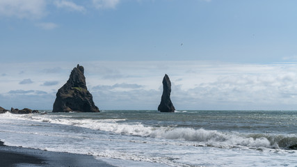 The black sand beach of Reynisfjara with rock formations in the sea, southern coast of Vik, Iceland