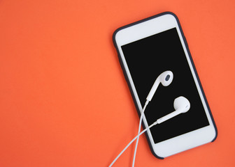 Headphones on the smartphone. Top view. White headphones